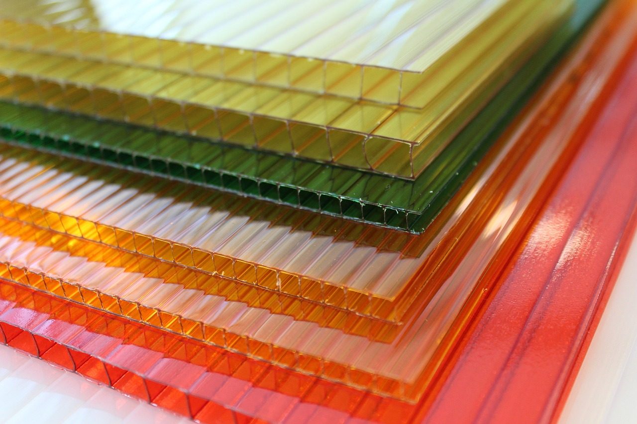 Plaques alvéolaires colorées empilées, présentant des teintes transparentes variées.